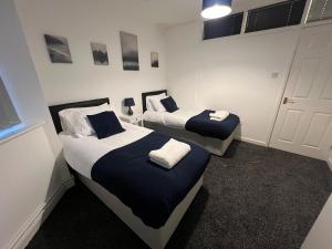 En eller flere senge i et værelse på Spacious 4-Bed Bungalow with Games Room & Parking