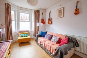 a living room with a couch and guitars on the wall at Exesixteen in Exeter