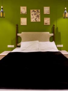 Un dormitorio verde con una cama con una manta negra. en Yara Villa, en Jāmb