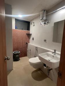 Un baño con un inodoro blanco y un lavabo. en Yara Villa, en Jāmb