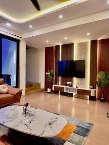 Una sala de estar con un sofá y un televisor. en Yara Villa, en Jāmb