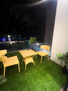 Un patio con dos mesas y sillas en un balcón por la noche. en Yara Villa, en Jāmb