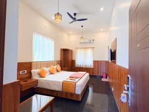 Un dormitorio con una cama y un ventilador de techo. en Yelagiris Honey Stay, en Yelagiri 8 fotos más