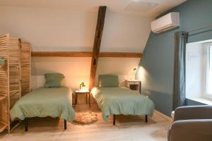 Saint-BéronにあるLe petit refugeのベッド2台とソファ1台と窓のある部屋