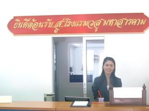 Vasu Hotel Mahasarakham في مها ساراخام: امرأة تجلس في مكتب +9 صور