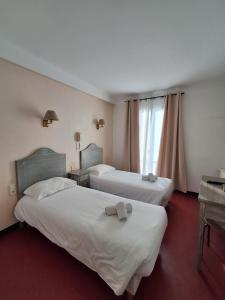 a hotel room with two beds and a window at FASTHOTEL Le Costabonne in Prats-de-Mollo-la-Preste