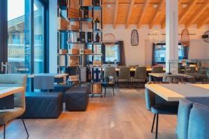 a restaurant with tables and chairs and windows at Black Summit Samnaun Boutique Hotel in Samnaun