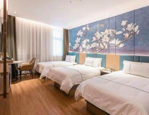 um quarto de hotel com duas camas e uma pintura na parede em Magnotel Business Harbin Railway Station Qiulin Museum Metro Station em Harbin mais 123 fotografias