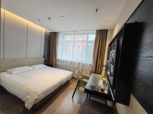 um quarto com uma cama e uma TV de tela plana em Magnotel Business Harbin Railway Station Qiulin Museum Metro Station em Harbin