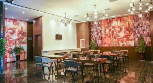 a restaurant with tables and chairs in a room at Zmax Changzhi Bayi Square in Changzhi