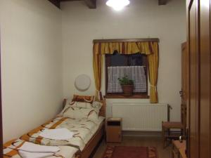 a small bedroom with a bed and a window at Öreg Somfa Vendégház in Uppony