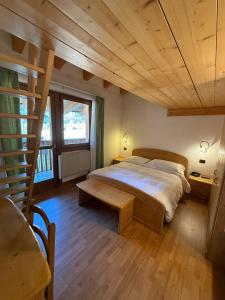 Hotel Villa Fosine في بينزولو: غرفة نوم بسرير كبير وسقف خشبي +125 صورة