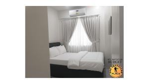 ein kleines Schlafzimmer mit einem Bett und einem Fenster in der Unterkunft One Travelers Place in Koronadal