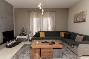 a living room with a couch and a christmas tree at Mary Luxury House in Émbonas +53 photos