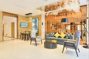 a living room with a blue couch and a table at City Comfort Inn Enshi Jingang Baijia Plaza in Enshi