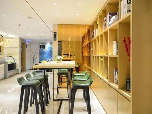 a dining room with a table and green chairs at City Comfort Inn Enshi Jingang Baijia Plaza in Enshi