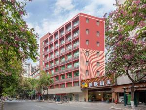 a tall red building on a city street at Zmax Hotel Guangzhou Railway Station in Guangzhou