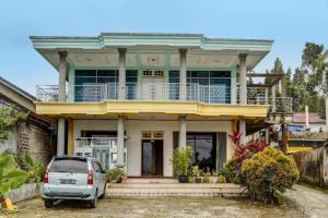 a car parked in front of a house at Hotel O Penginapan Aina Syariah in Rantaupanjang