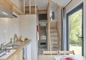 a tiny house with a kitchen and a staircase at Weekend Glamping Resort in San Felice del Benaco