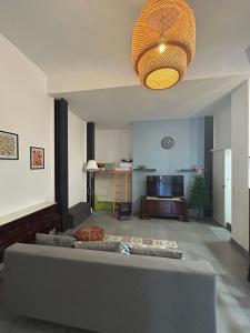 ein Wohnzimmer mit einem großen Sofa und einer großen Lampe in der Unterkunft MaiFamilyBCN-Cómodo Y Para familia Y Metro Cercano in Badalona