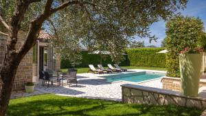 a patio with chairs and a swimming pool at Rustic villa Inga with pool and grill in Buje in Kaštel