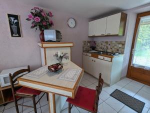 a kitchen with a table with a vase of flowers on it at Chambre d'hôtes du Moineau in Le Val-dʼAjol
