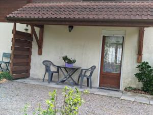 a table and chairs in front of a house at Chambre d'hôtes du Moineau in Le Val-dʼAjol