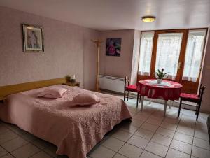 a bedroom with a bed and a table and windows at Chambre d'hôtes du Moineau in Le Val-dʼAjol