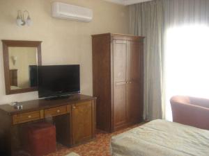 a hotel room with a television on a wooden dresser at Candan Beach Hotel in Marmaris