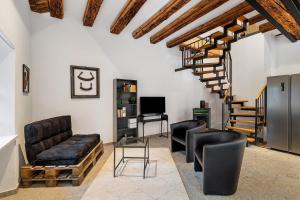 a living room with leather furniture and a staircase at Historische Werkstatt in Gernsbach