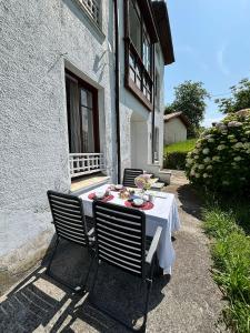 Gestiona2R - Narganes Mar y Montaña, ideal familias في Narganes: طاولة مع قطعة قماش بيضاء على الفناء