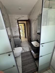 Un baño con lavabo, inodoro y espejo. en ardan, en Amán