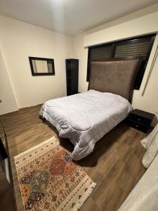 Un dormitorio con una cama grande y una alfombra. en ardan, en Amán
