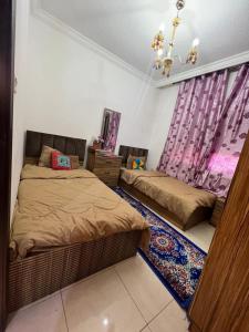 Un dormitorio con dos camas y una ventana. en ardan, en Amán