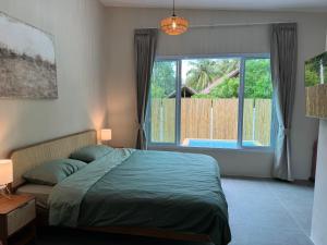 a bedroom with a bed and a large window at Pool Villa Mango 2BR in Koh Phangan