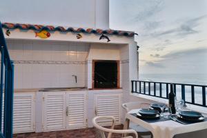 a kitchen with a table and chairs on a balcony at Casa da Praia - Vista Mar in Ericeira