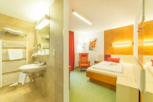 una camera d'albergo con un letto e un bagno di VitalZeit Hotel Weber a Bad Schönau