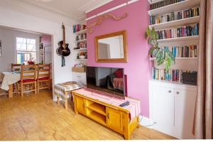 a living room with a fireplace and a pink wall at Exesixteen in Exeter +25 photos