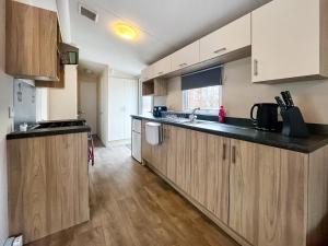 a kitchen with wooden cabinets and a counter top at Jordana Lodge in Edzell