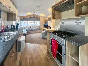 a kitchen with a stove and a living room at Jordana Lodge in Edzell