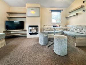 a large living room with a couch and a television at Jordana Lodge in Edzell