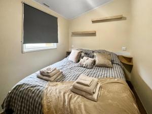a bedroom with a bed with towels on it at Jordana Lodge in Edzell +5 photos
