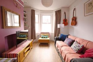 a living room with a couch and a guitar at Exesixteen in Exeter