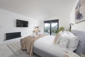 Copper Tree في Cubert: غرفة نوم بيضاء مع سرير كبير وتلفزيون