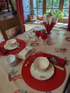 VaudoncourtにあるChambre avec Salon, Chez Marie-Joの赤白の皿とワイングラスを用意したテーブル