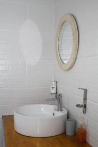 a white bathroom with a sink and a mirror at Moxwini Self Catering Apartments in Maun