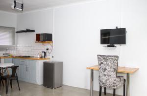 a kitchen with a table and a tv on the wall at Moxwini Self Catering Apartments in Maun +23 photos