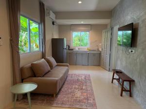 a living room with a couch and a kitchen at Pool Villa Mango 2BR in Koh Phangan