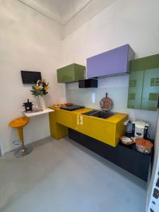une cuisine avec des armoires jaunes et vertes et une table dans l'établissement A' Cantunera - Apartment, à Taormine