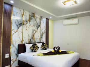 een slaapkamer met een groot wit bed met een schilderij aan de muur bij New Ozone Resort & Spa in Koh Lanta